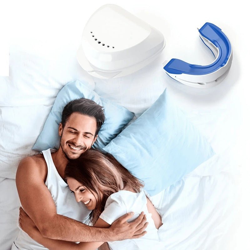 A couple lies on a bed with light blue pillows, smiling and embracing each other. Above them is a white case containing the blue-and-white Adjustable Snoring Solution Mouthpiece by Aloha Relax, promising snore-free sleep.