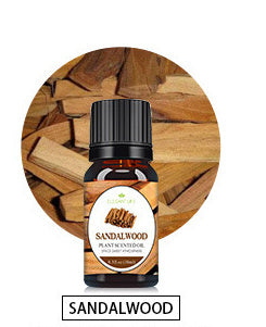 A bottle of essential oil from Aloha Relax is placed in front of a circular background featuring pieces of sandalwood. The label reads "Aloha Relax." When used with the Flame Aroma Diffuser Air Humidifier Ultrasonic Cool Mist Maker Fogger LED Essential Oil Lamp, this oil enhances tranquility, elevating the ambiance with 7 colors and maintaining a low noise level.