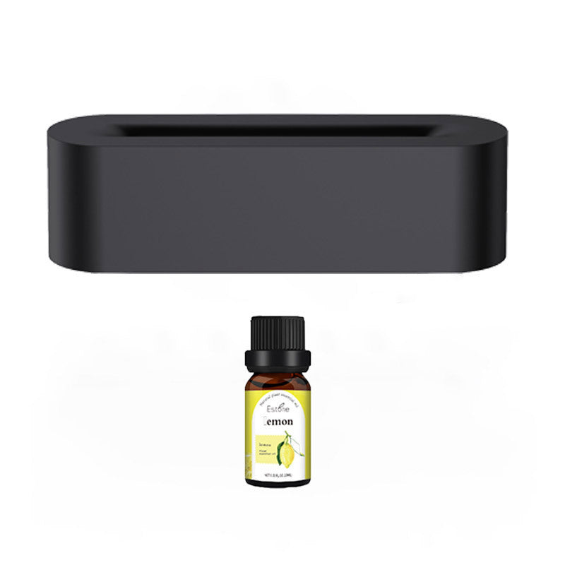 The Aloha Relax Flame Aroma Diffuser, a rectangular black diffuser with ultrasonic cool mist capabilities, is paired with a small bottle of lemon essential oil. The bottle includes a label displaying a lemon image and text. They are placed against a simple white background, designed to provide low noise levels for a tranquil environment.