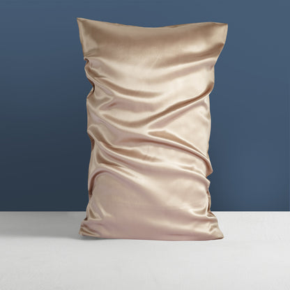 A Double-sided Silk Silk Heavy Sleep Pillowcase by Aloha Relax, in a satin gold color, exudes a light luxury vibe with its crumpled texture. It is set upright against a blue background on a light gray surface, showcasing the exquisite smoothness and shine reminiscent of palace luxury style.