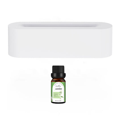 A small amber bottle with a black cap labeled "Jasmine Essential Oil" rests in front of a white rectangular wall-mounted shelf, ideal for use with the Aloha Relax Flame Aroma Diffuser, an ultrasonic cool mist maker and essential oil lamp that enhances your relaxation experience with its realistic fire feature.