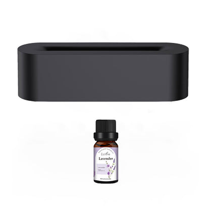 A rectangular black Aloha Relax Flame Aroma Diffuser Air Humidifier stands above a small brown bottle labeled "Lavender," featuring a black cap and a white label with purple and green graphics. This diffuser, equipped with ultrasonic humidification, enhances the ambiance against a white backdrop by offering 7 colors of soothing light.