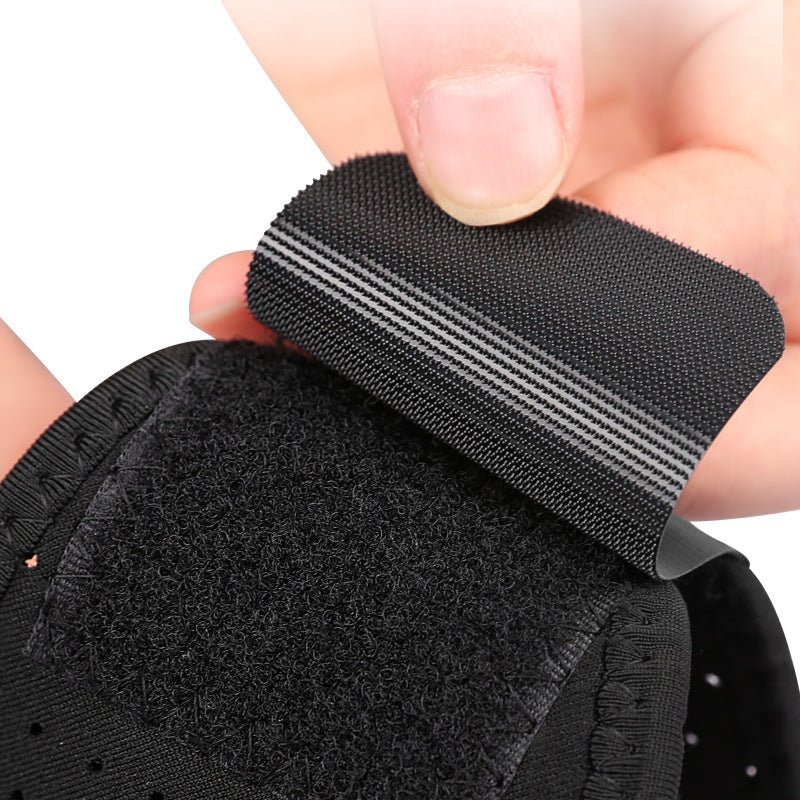 A hand adjusts the black Velcro strap of Aloha Relax's Adjustable Chin Strap to Reduce Snoring. The ergonomic sleep aid features a hook and loop fastening with a striped design, as the hand prepares to attach the loop section for optimal snoring reduction.