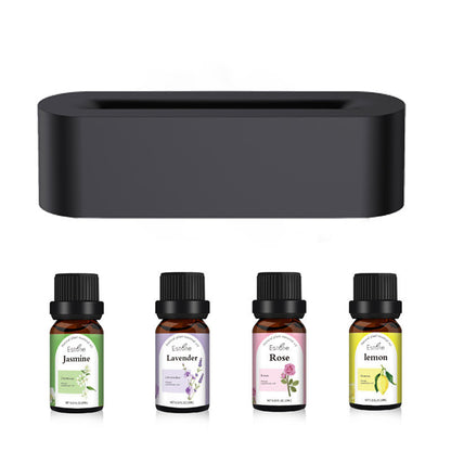 A sleek black Flame Aroma Diffuser by Aloha Relax is presented alongside four essential oil bottles labeled Jasmine, Lavender, Rose, and Lemon. Each bottle includes a small botanical illustration corresponding to its scent. This ultrasonic humidification device enhances your environment with calming aromas.